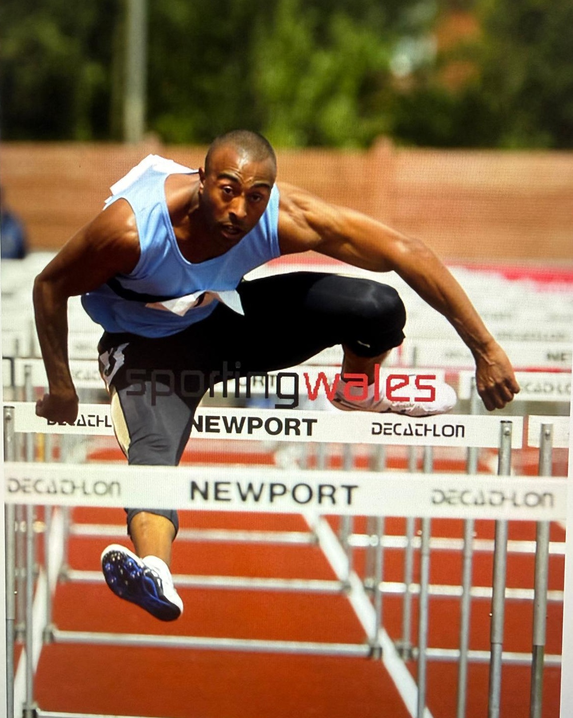 Colin Jackson CBE clearing a hurdle in competition at Newport